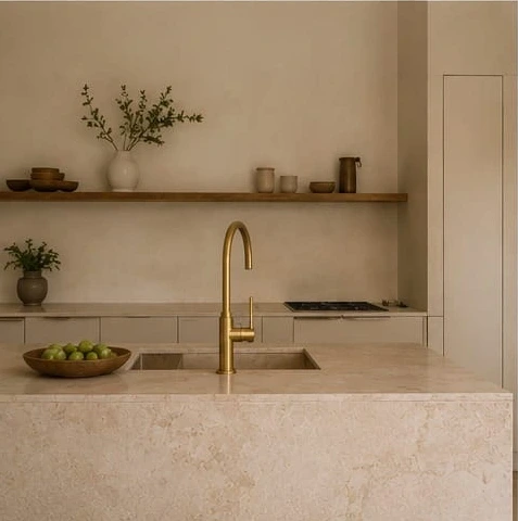 High-end Mediterranean kitchen with a stone island and unlacquered brass tap
