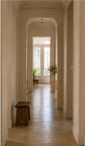 Light-filled Mediterranean hallway with stone flooring and a handcrafted wooden bench